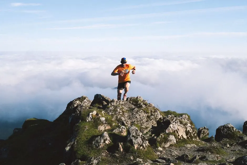 Un traileur court sur un sentier de montagne rocailleux, avec un panorama de sommets à 2 000 m